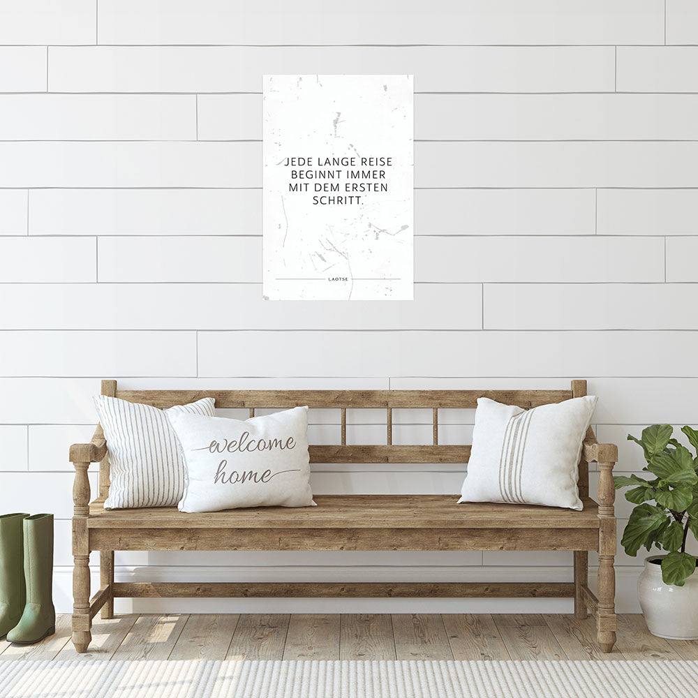 Poster mit Spruch Jede lange Reise beginnt immer mit dem ersten Schritt auf weissem Hintergrund